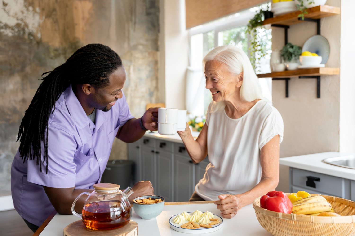 A carer having a cup of tea and a fun conversation with his home care client. More quality time for them both thanks to eMAR systems and digital care records.
